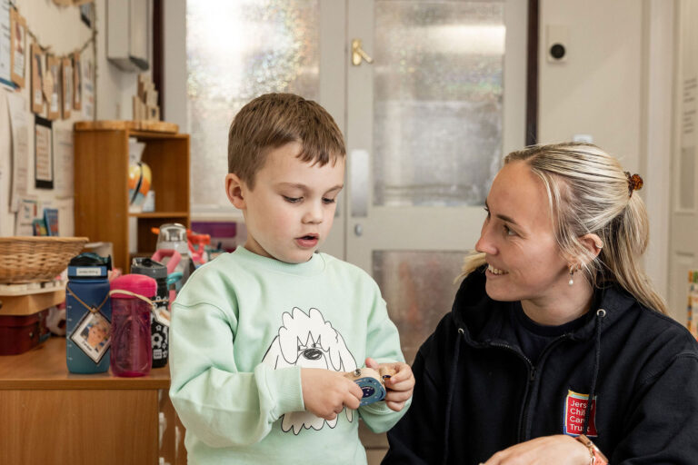 A woman and a child are happily playing, sharing smiles and laughter in a cozy environment.