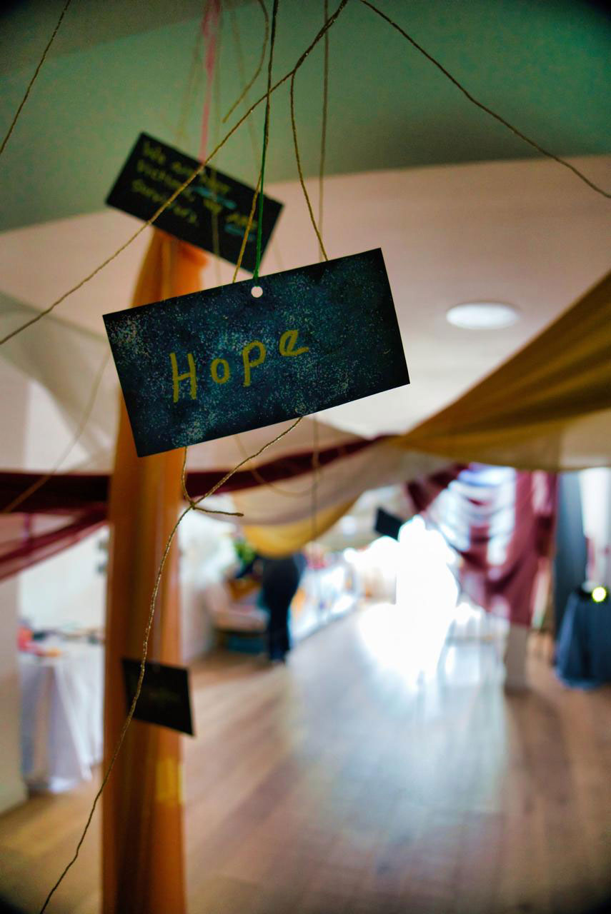 A sign dangling from a string, showcasing the message 'Hope'.