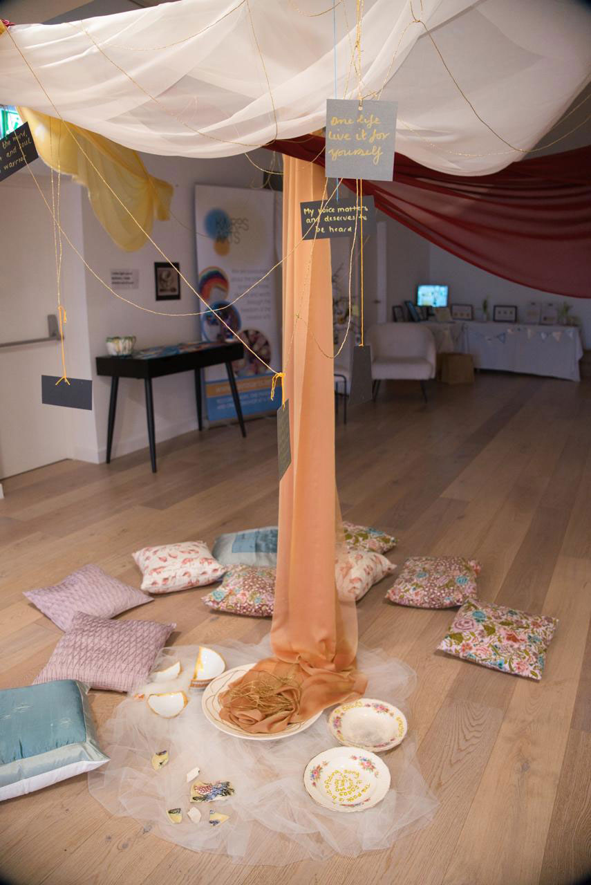 A creative display hanging from beneath a decorative canopy.